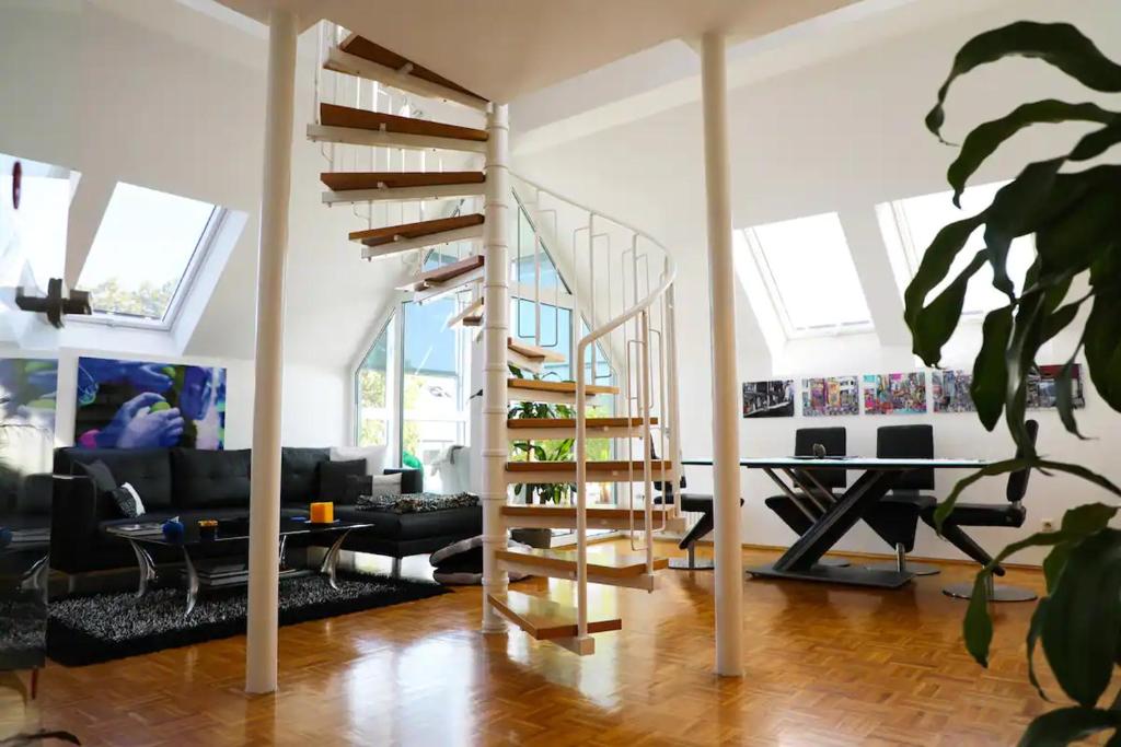 a living room with a spiral staircase in a house at Modern luxury duplex in Düsseldorf-Benrath in Düsseldorf