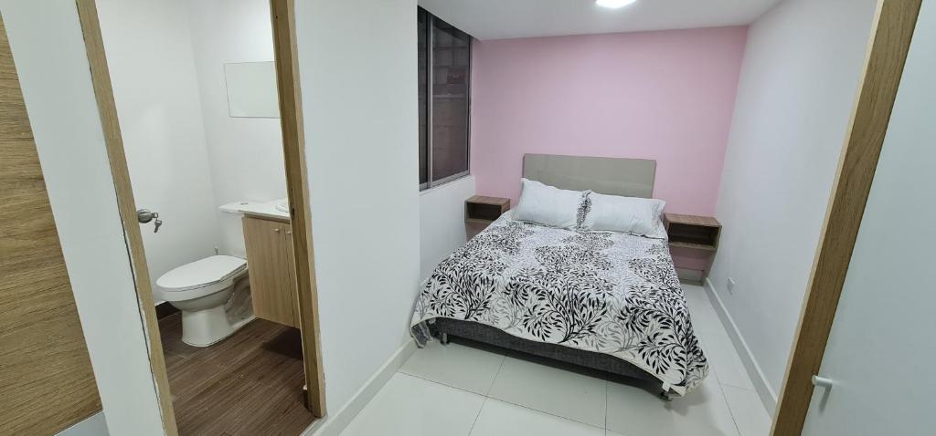 a small room with a bed and a toilet at Hermosa casa en Medellin. Cerca a estación del metro in Medellín
