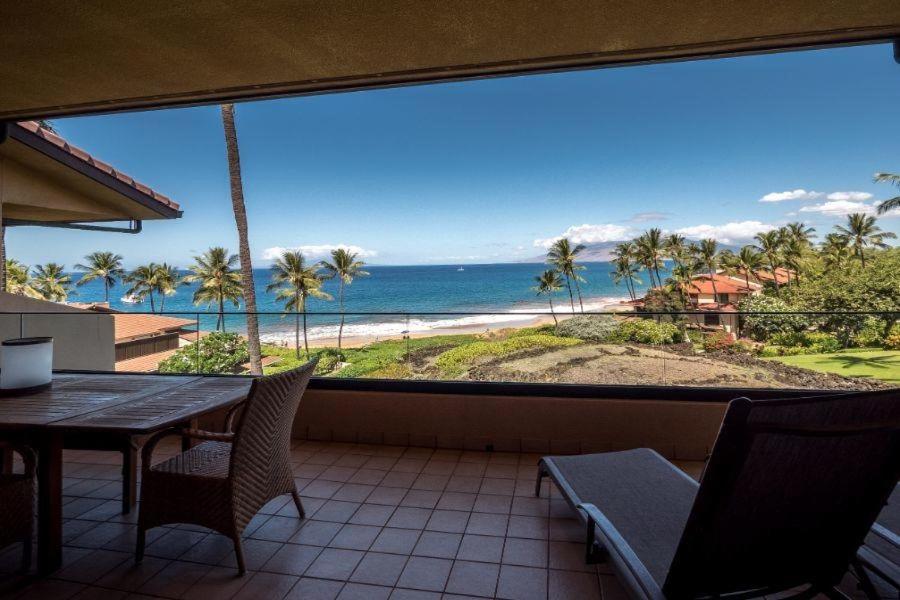 a balcony with a table and chairs and a view of the beach at MAKENA SURF, #C-205 condo in Wailea