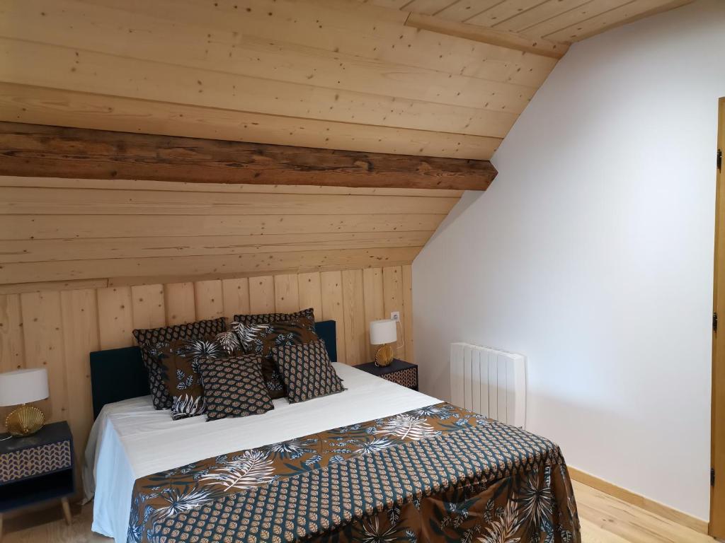 Rochefort-sur-NenonにあるL'Alcôve des Falaisesの木製の天井のベッドルーム1室(ベッド1台付)