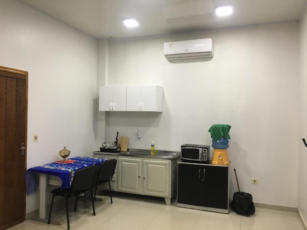 a small kitchen with a table and a microwave at Monoambiente en Ciudad del Este - Py in Ciudad del Este