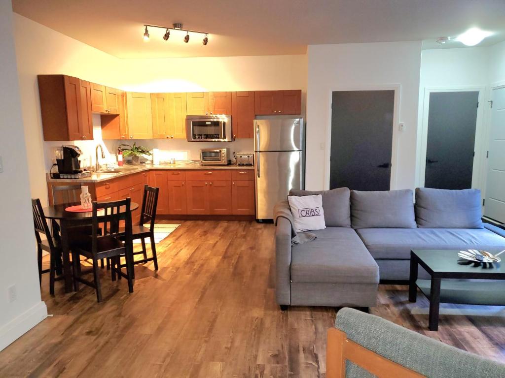 a living room and kitchen with a couch and a table at Cribs on the Hill in Picton