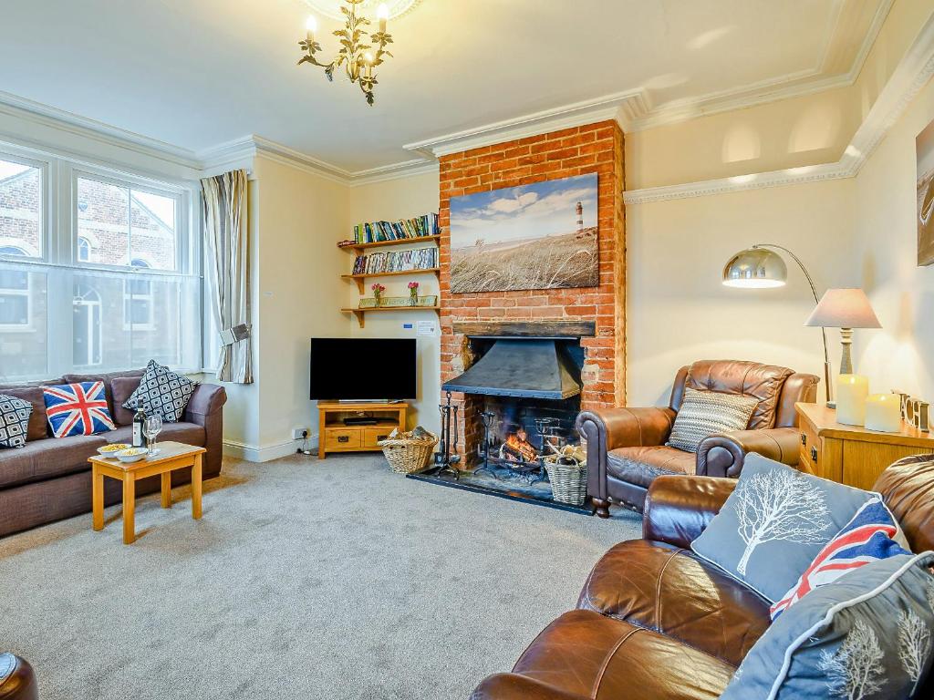 a living room with couches and a fireplace at Beach House in Sea Palling