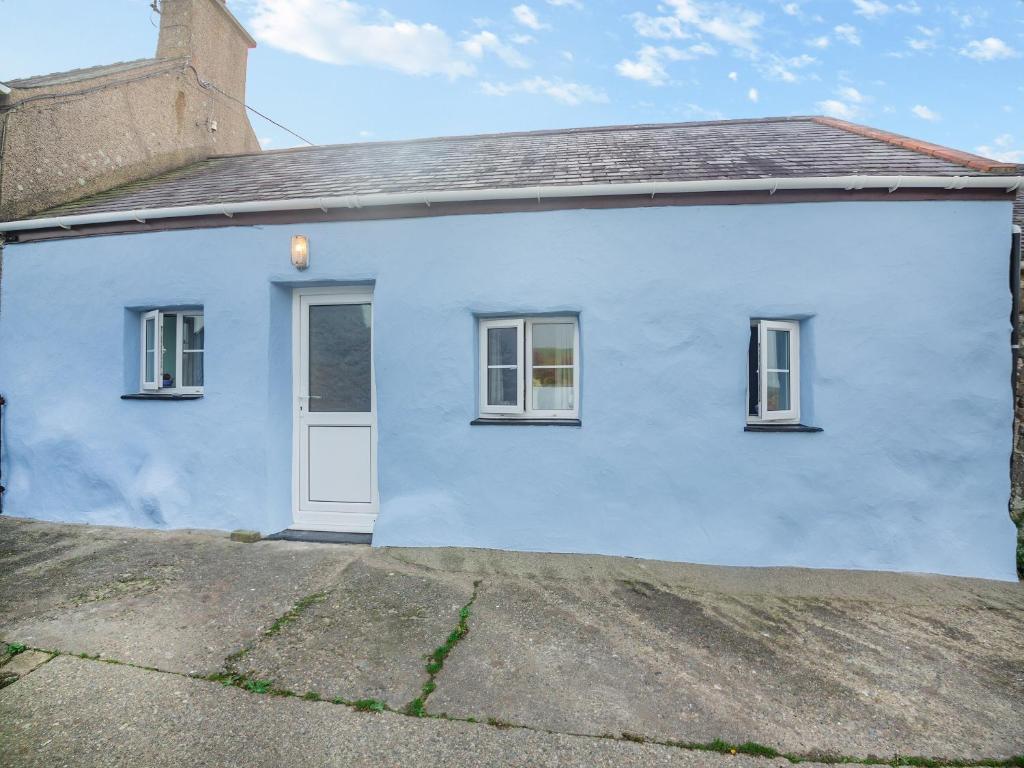 Casa blanca con puerta blanca y 2 ventanas en Ty Canol, en Llanfaelrhys