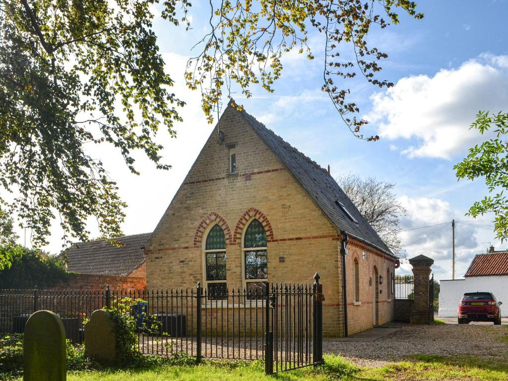 a church with a black fence in front of it at Chapel Lodge in Hornsea