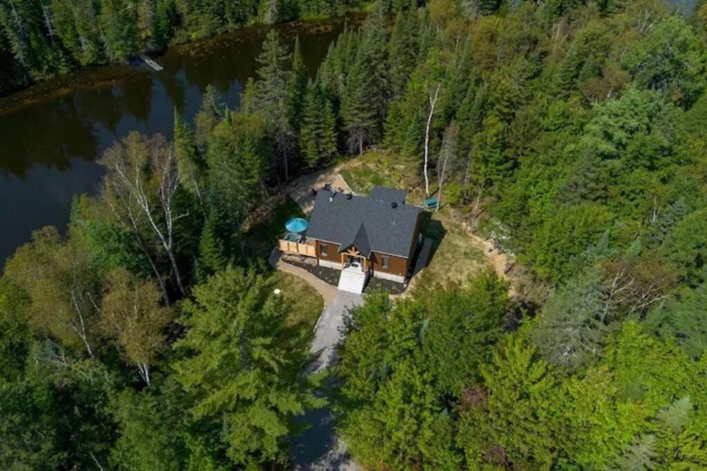 una vista aérea de una casa en medio de un río en Le Petit Saphir en Rawdon