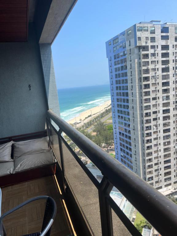 un balcón con vistas a la playa y a un edificio en Apartamento em frente à praia Barra da Tijuca en Río de Janeiro