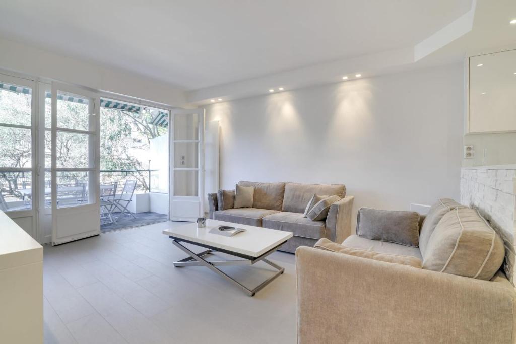 un salon avec deux canapés et une table dans l'établissement Appartement calme et confortable -terrasse- Cannes, à Cannes