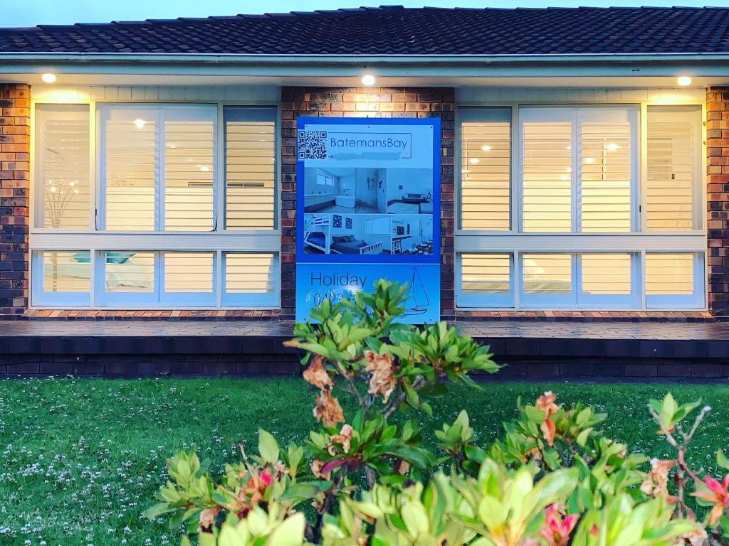 a house with a window with shutters on it at Surfside Holiday Home 100m Beach in Batemans Bay