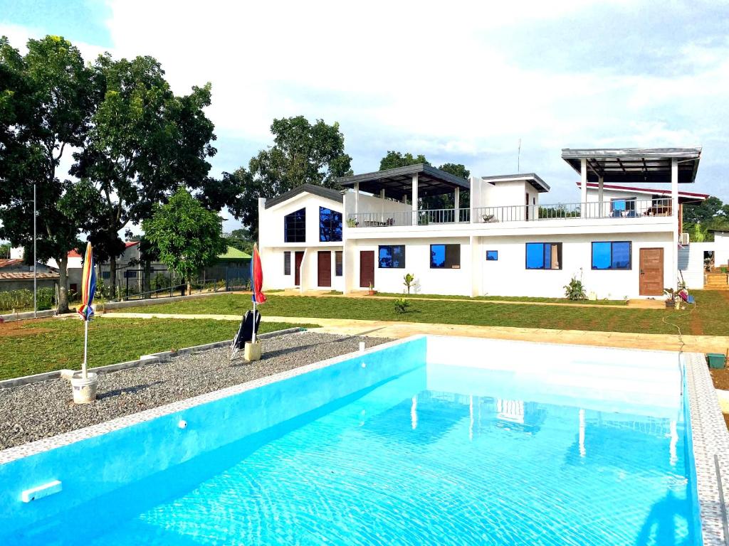 une maison avec une piscine en face d'une maison dans l'établissement Casa Concetta Apartelle with Pool, à Manolo Fortich