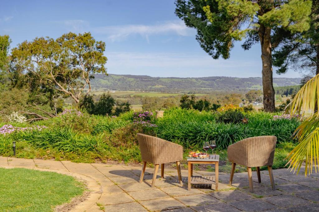 a patio with two chairs and a table with a view at Amongst the Vines Deluxe Retreat in Blewitts Springs