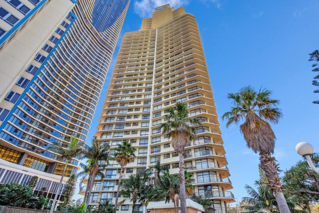 黄金海岸Beachfront & City View, Huge 2 Bedroom Apartment, Imperial Surf Resort的两座高大的楼房,前方有棕榈树