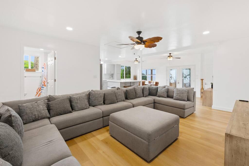 a living room with a gray couch and a table at Shark's Cove Front, Sea View, Large 2BR, Full Kitchen, contact us for price drop in Haleiwa