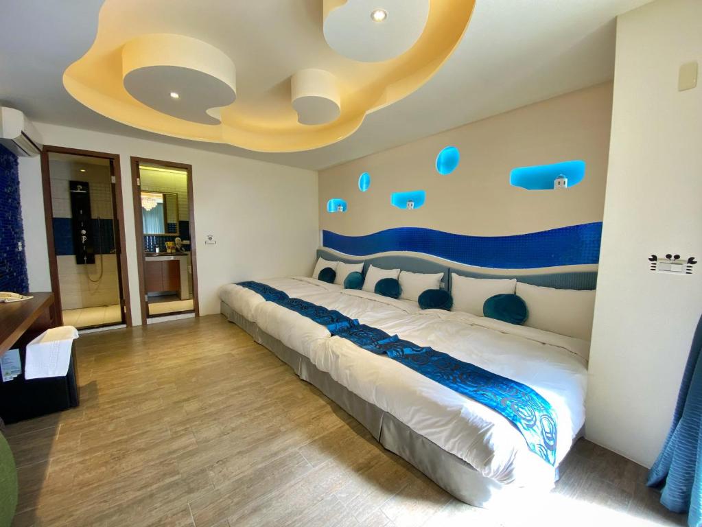 a bedroom with a bed and a ceiling with blue accents at Dream Ocean View B&B in Magong