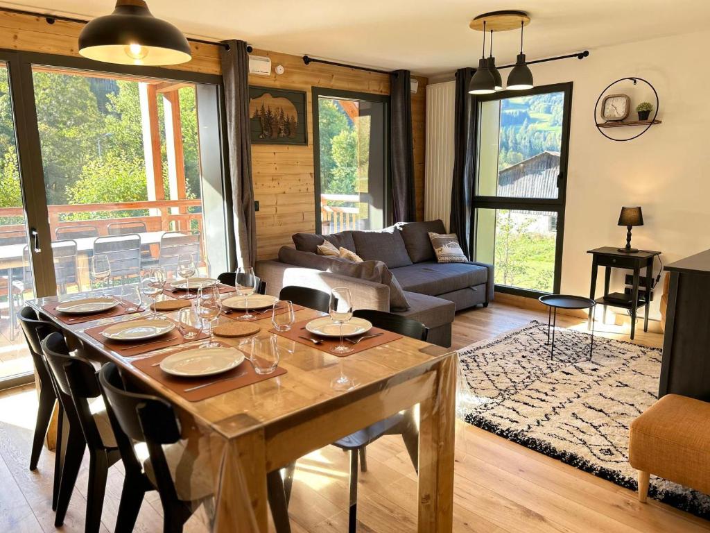 - un salon avec une table et des verres à vin dans l'établissement Appartement neuf aux Gets, proche remontées mécaniques, terrasse sud, 6 couchages, garage, WiFi - FR-1-623-350, aux Gets