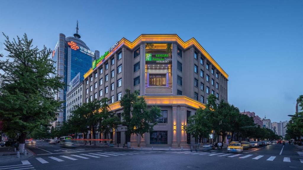 un edificio alto en una calle de la ciudad con una calle en Holiday Inn Express Dandong City Center, an IHG Hotel en Dandong