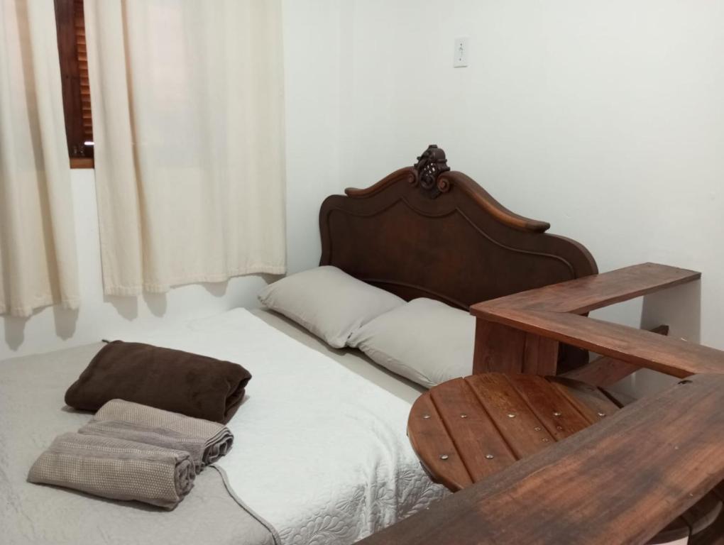 a bedroom with a bed with a wooden head board at Mini Casa Furnas - Capitólio MG in São José da Barra