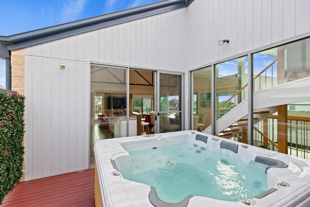 bañera de hidromasaje en la cubierta de una casa en Bliss on the Bay - Full House en Rye