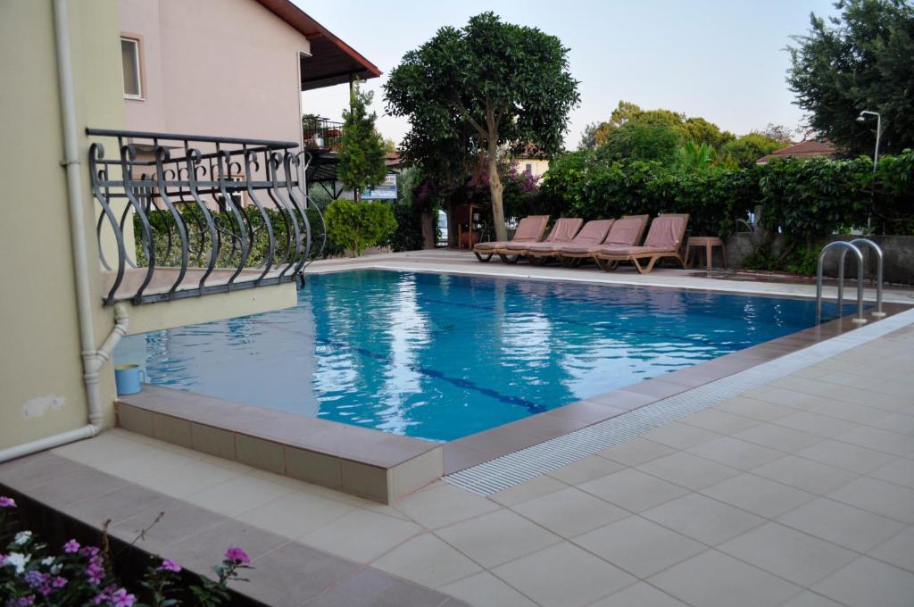 a swimming pool with benches next to a building at Dogan Apart Hotel in Göcek