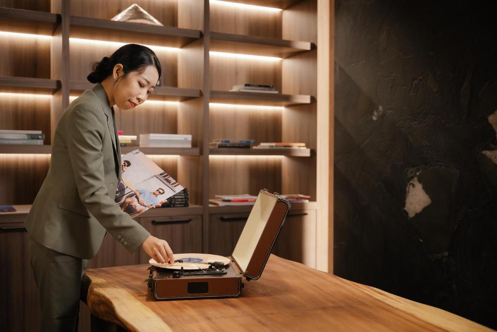 A wood worktable styled with a vintage record player in a library-like lounge.