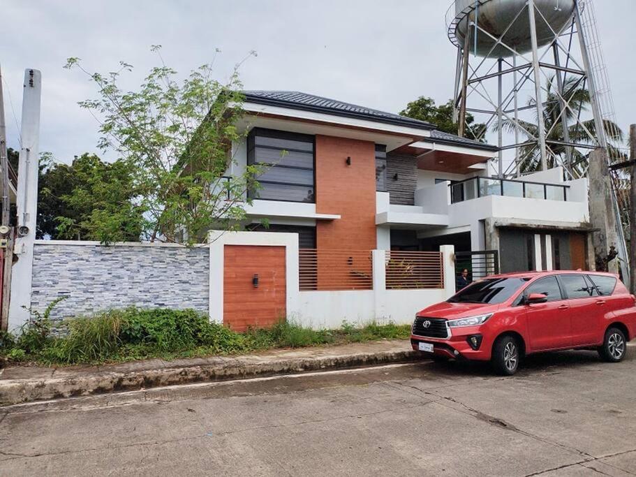 ein rotes Auto, das vor einem Haus parkt in der Unterkunft Home in Bacolod in Bacolod City