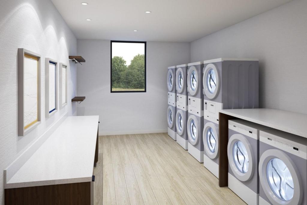 eine Waschküche mit einer Reihe von Waschmaschinen und Trocknern in der Unterkunft Staybridge Suites Dallas Market Ctr Love Field, an IHG Hotel in Dallas