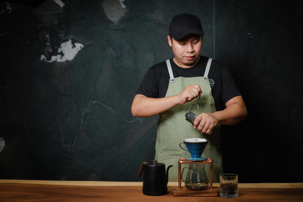 A barista works at a pour-over coffee counter.