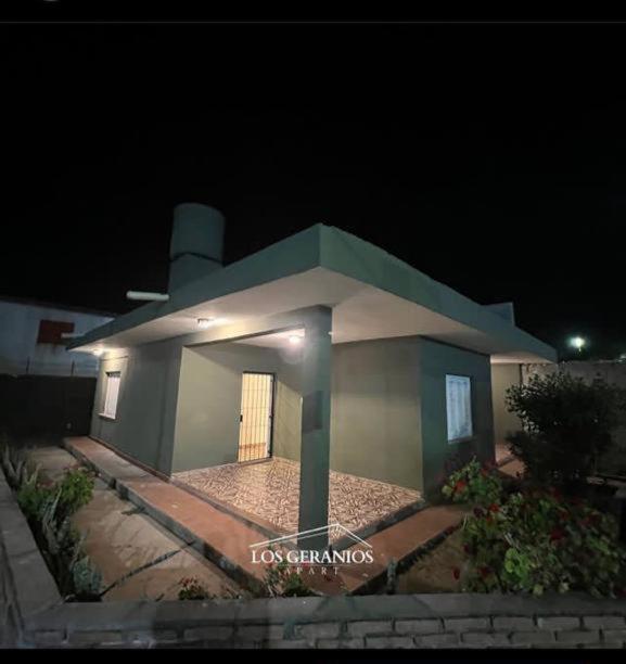 a small building with a door in the night at Los Geranios Apart in Villa Cubas