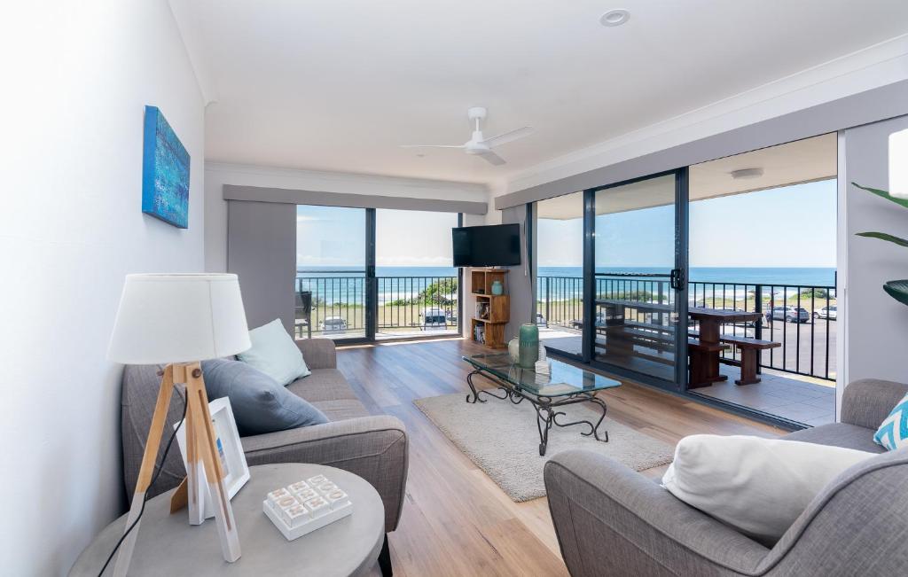 a living room with a view of the ocean at Edgewater 1 - LJHooker Yamba in Yamba