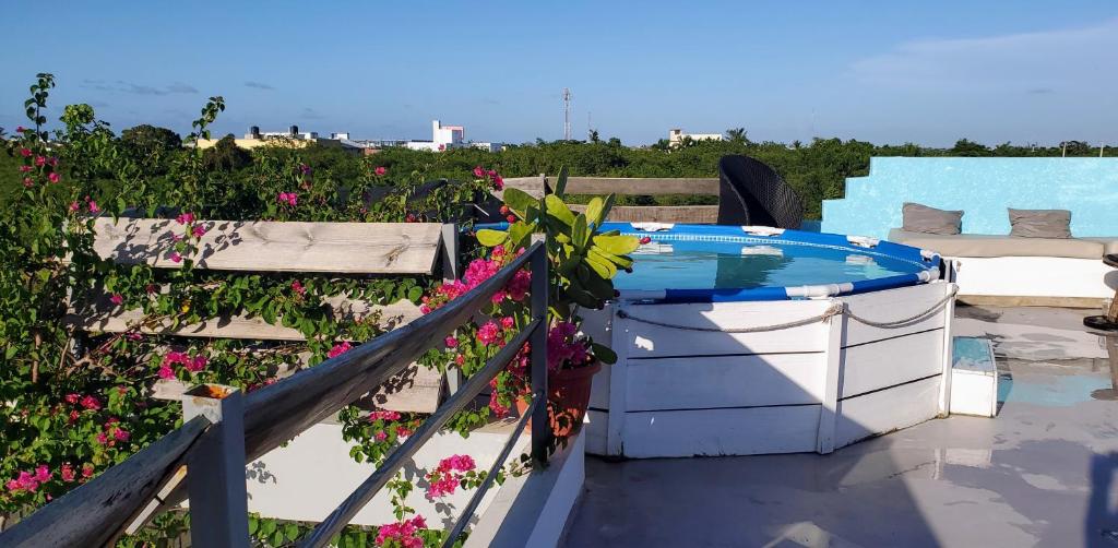 Dominican Dream Apartments في بونتا كانا: يوجد حوض استحمام ساخن على شرفة تحتوي على زهور