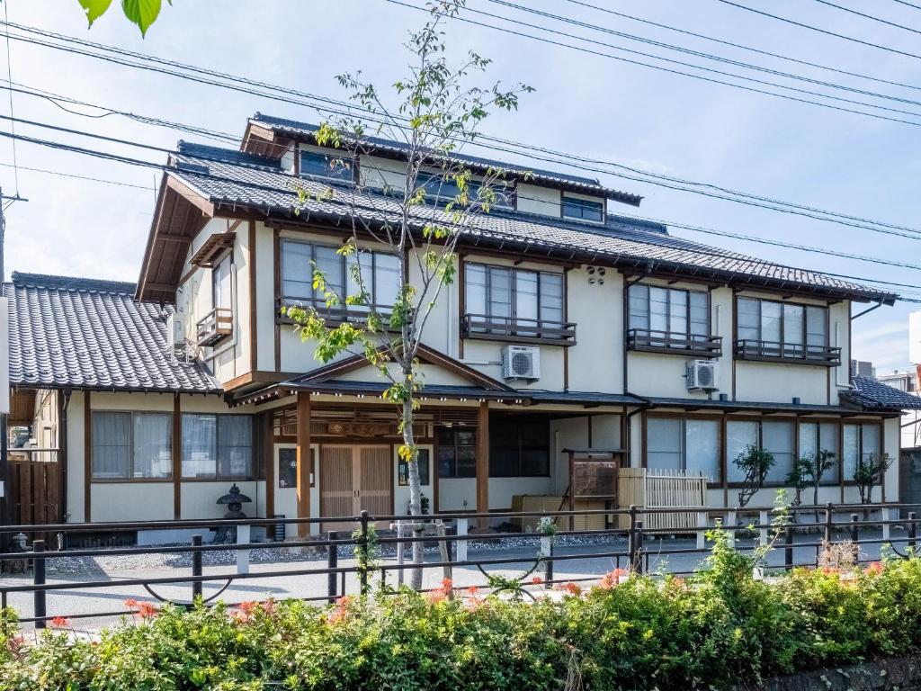 una casa con muchas ventanas en Tabist Fuji Sakura Onsen Ryokan en Fuefuki