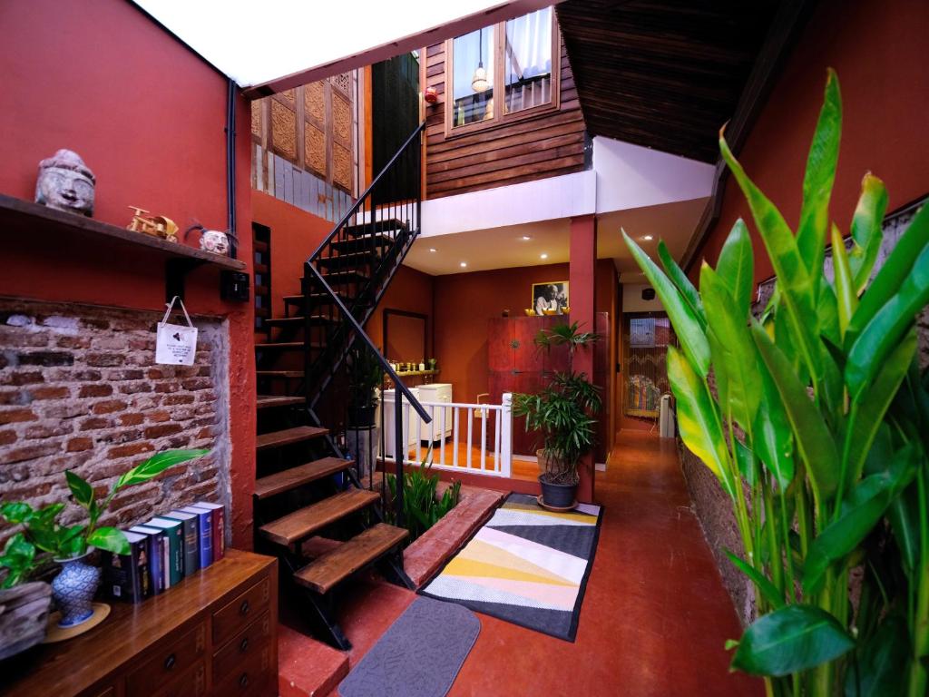 a room with a staircase and plants in a building at Rinvada House in Bangkok