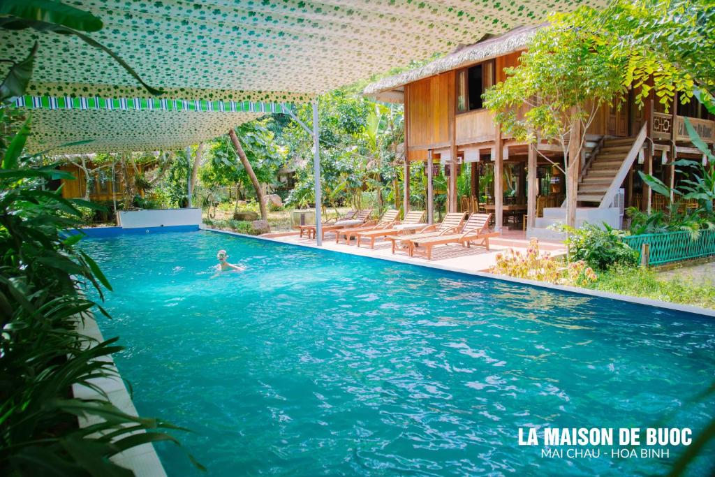 um homem a nadar numa piscina num resort em La Maison De Buoc em Mai Châu