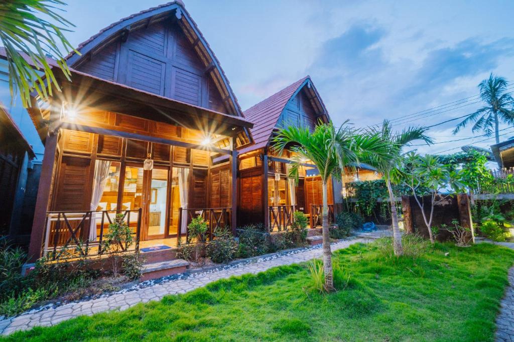 una casa con palme di fronte di Ba Bar Cottage Penida a Nusa Penida
