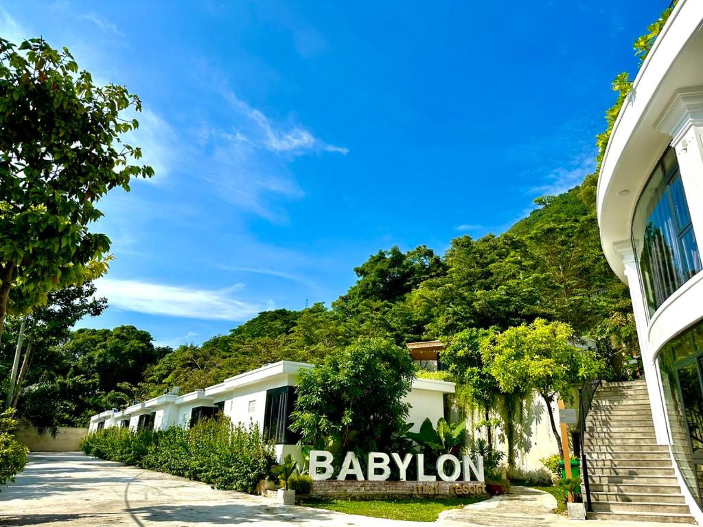 een rij gebouwen met een berg op de achtergrond bij Babylon Mini Resort in Vung Tau