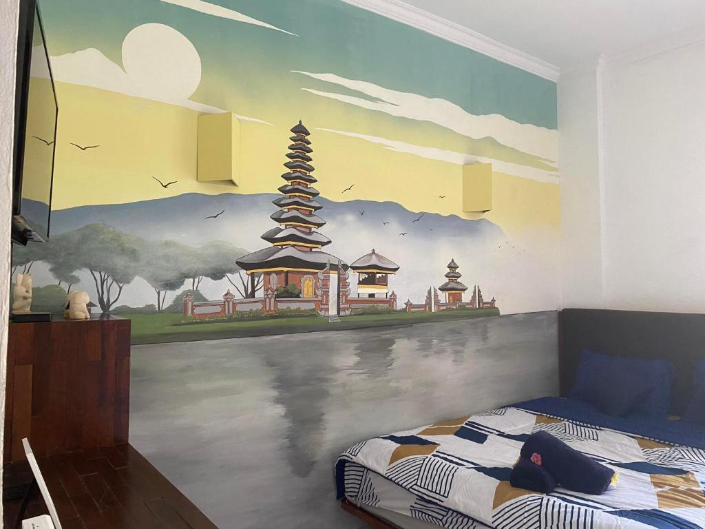 a bedroom with a mural on the wall at Jasmin Homestay in Sanur