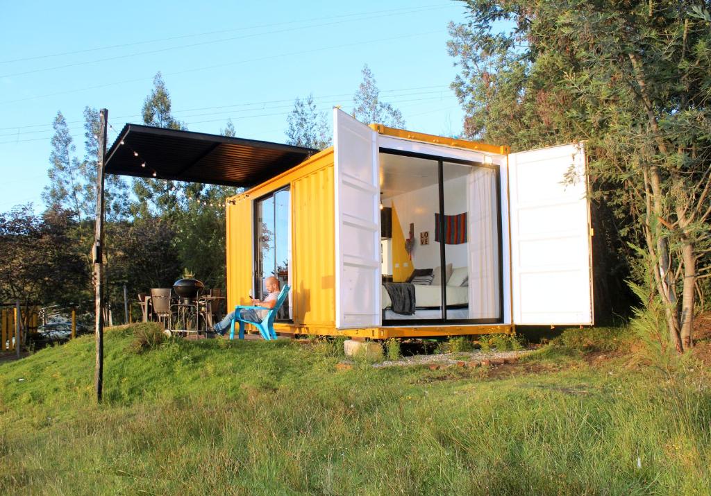 a person sitting in a yellow and white tiny house at Libre Camp Amarillo in Nemocón