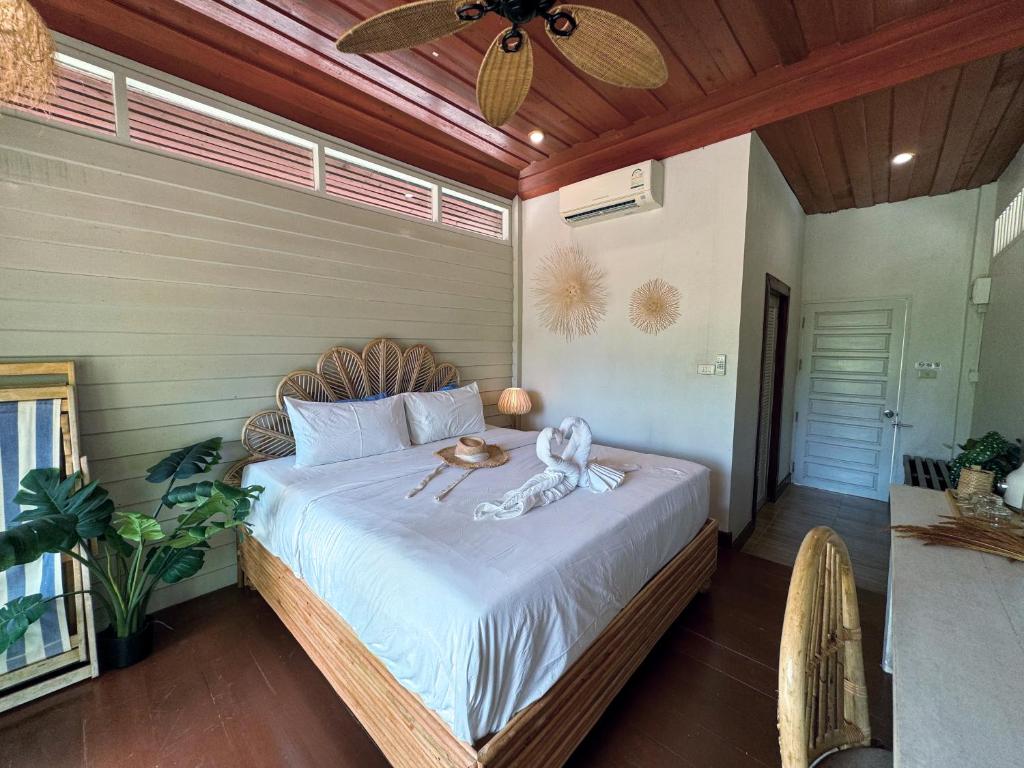 a bedroom with a large bed with a wooden headboard at À La Koh Kood Resort in Ko Kood