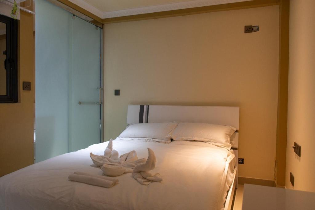 una camera da letto con un letto bianco e asciugamani di Fanfini Residence Male’ a Città di Malé