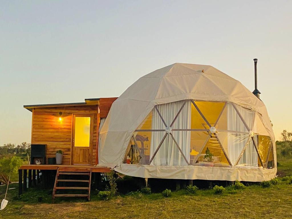une grande tente installée en face d'une cabine dans l'établissement FARMGLAMP, à Balneario Buenos Aires