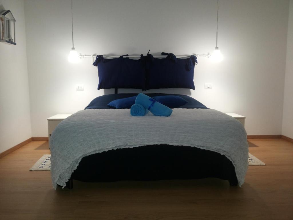 sypialnia z dużym łóżkiem z niebieskimi poduszkami w obiekcie I Colori di Mag w mieście La Spezia