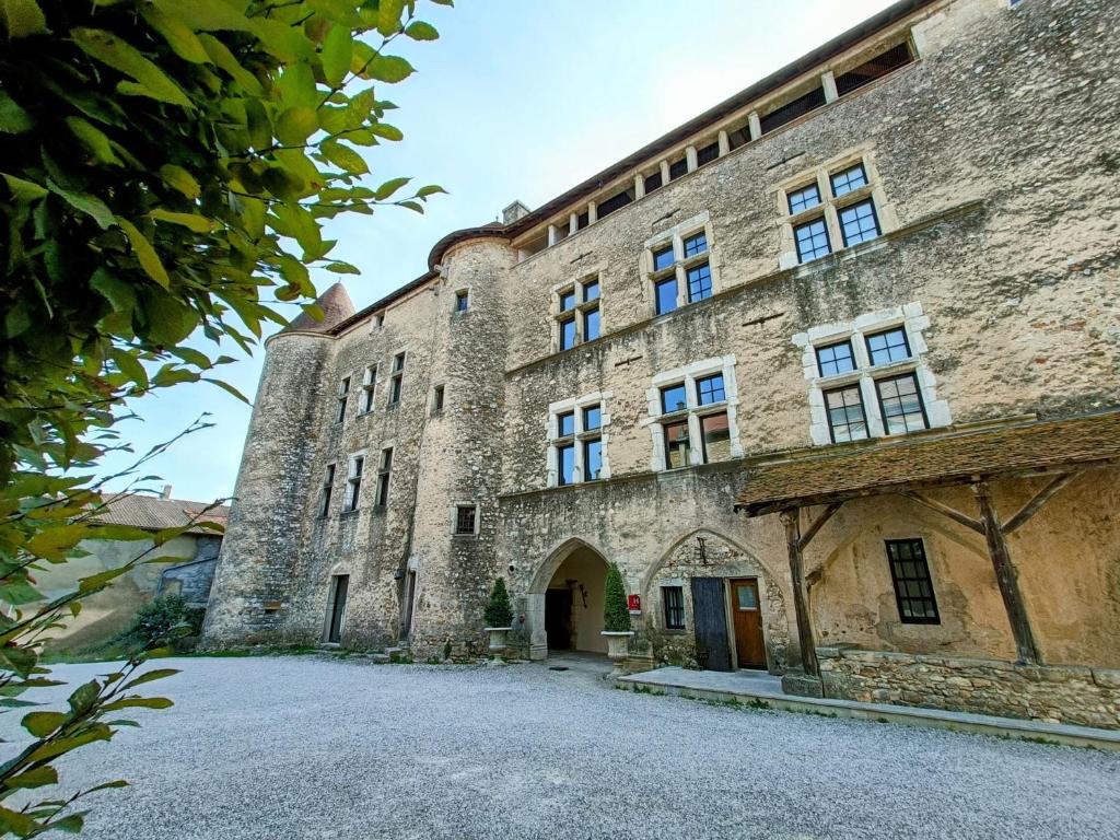 a large stone building with a driveway in front of it at Les Chambres De La Renaissance in Sainte-Julie