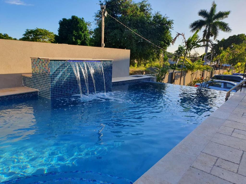 a swimming pool with a fountain in the middle at lovely gated 3 BEDROOM in Kingston