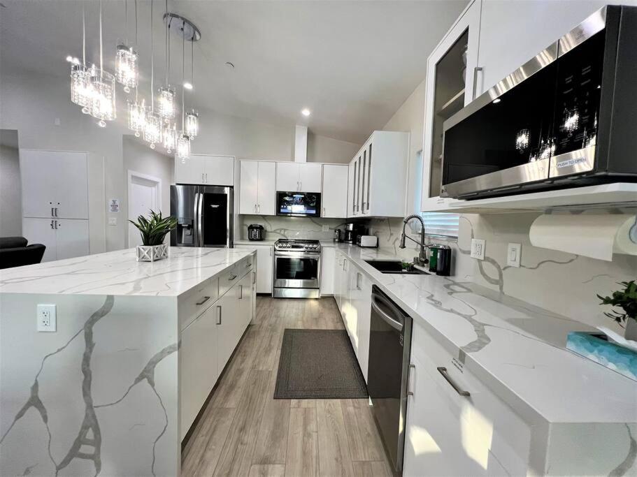 a kitchen with white cabinets and a large white counter top at New & Modern with Accessibility-Family Friendly in San Bernardino