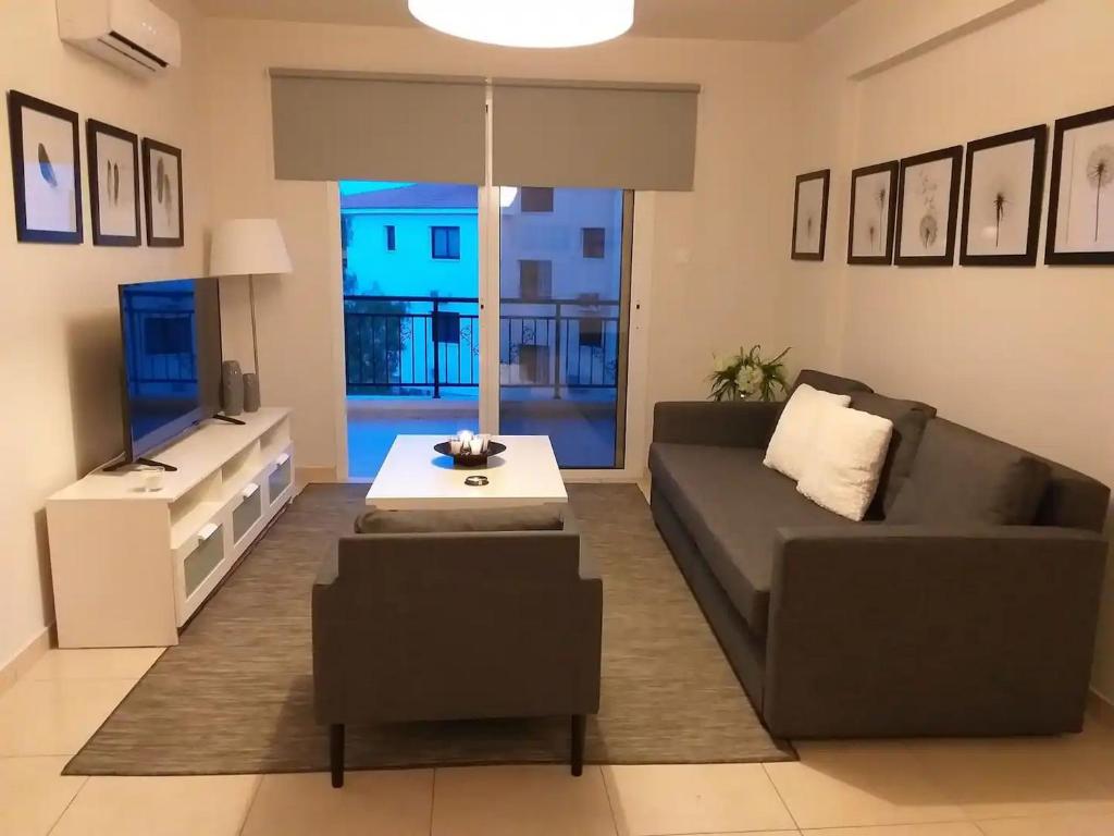 a living room with a couch and a tv at Artemis Panorama Escape Vacation in Tersephanou