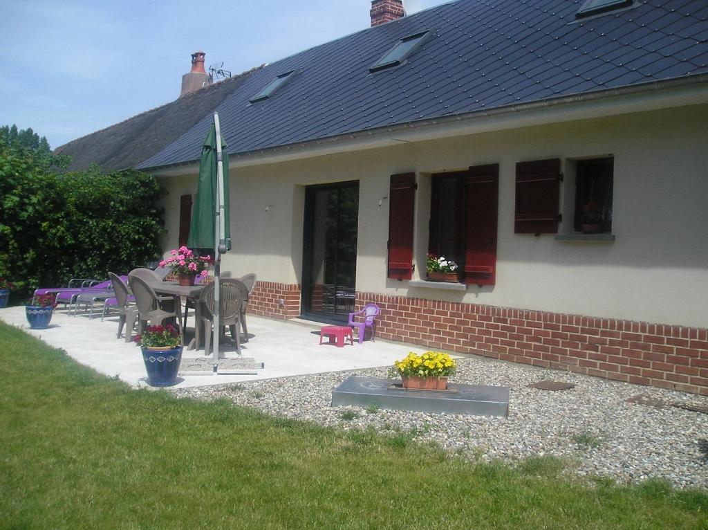 Casa con patio con mesa y sombrilla en Farm cottage de la Somme, en Moyenneville