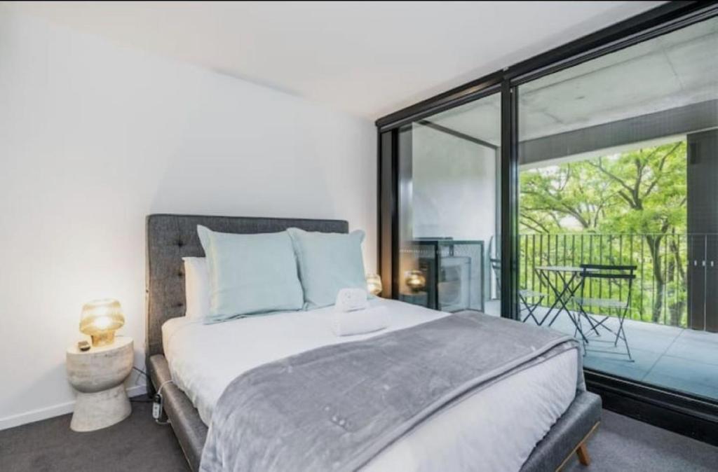 a bedroom with a large bed and a large window at Metropol 3 • Comfy• Luxury• Central • Free Parking in Canberra