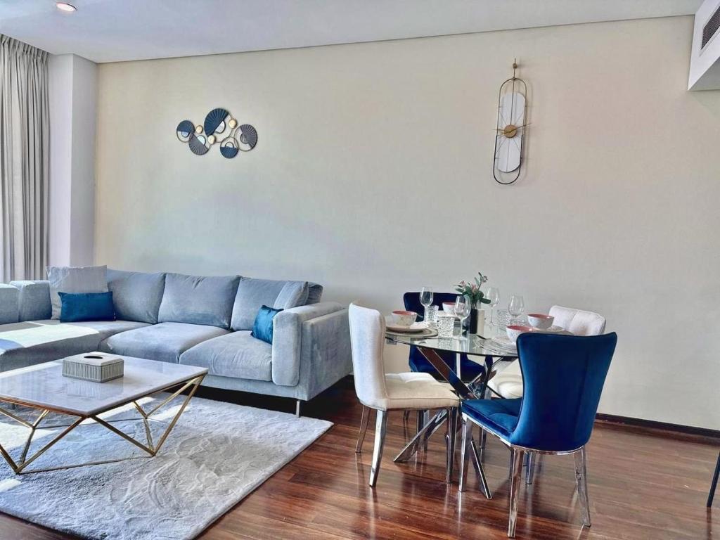 ein Wohnzimmer mit einem Sofa und einem Tisch in der Unterkunft Liberty House - 1BR Apartment - Allsopp&Allsopp in Dubai