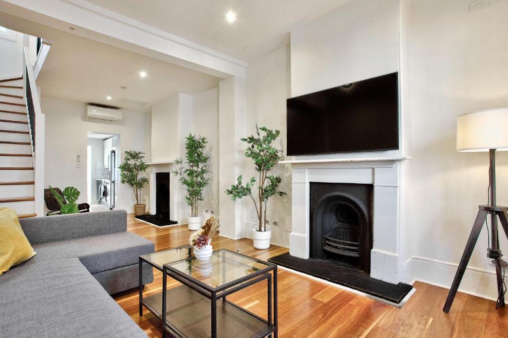 - un salon avec un canapé et une cheminée dans l'établissement 3 Bedrooms - Darling Harbour - Ada Place, à Sydney