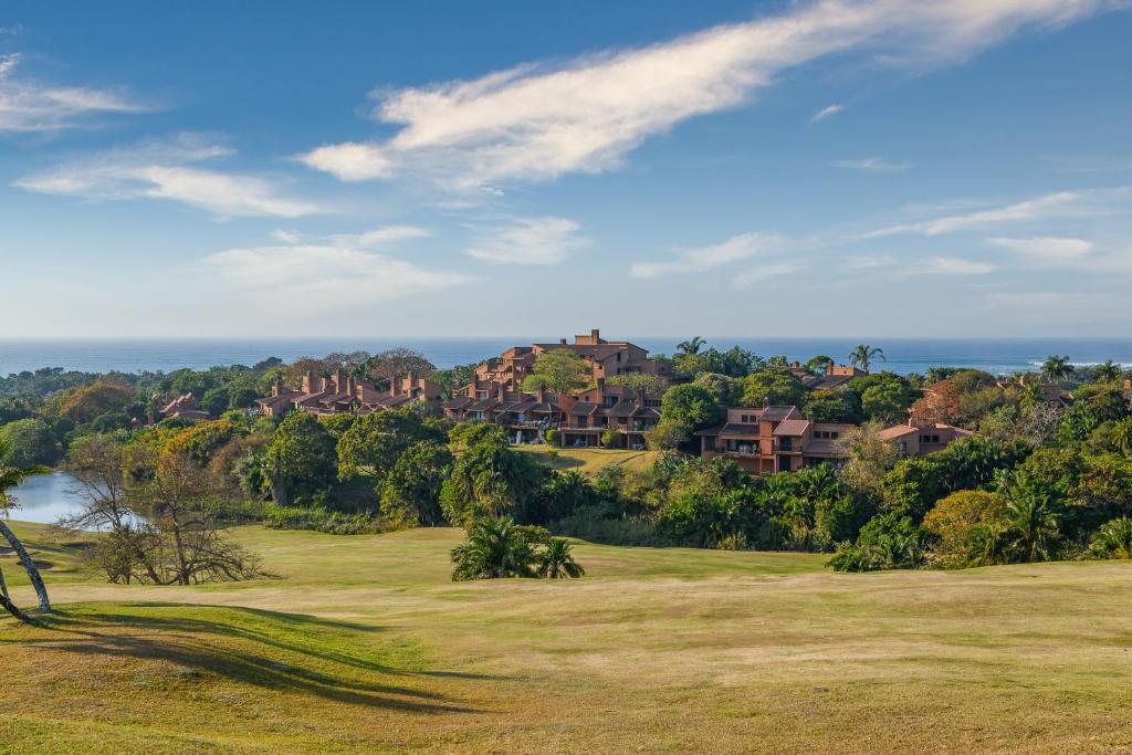 vista su un campo da golf con case sullo sfondo di San Lameer Villa 2909 a Southbroom